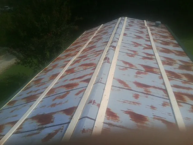Rusted metal roof panels with new wood purlins before replacement — Storm Damage Roof Repair in Hazlehurst by Roofing Brothers