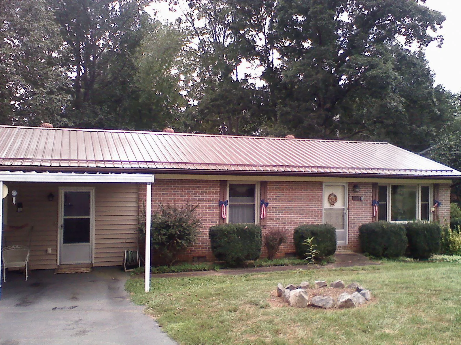 Bronze metal roof and carport on a brick ranch home — Roof Repair work by our crew in Hazlehurst